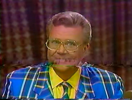 Rod is wearing a blue/black/yellow tartan jacket, matching tie & yellow shirt