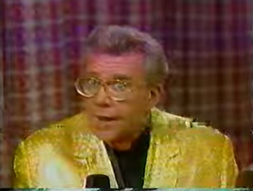 Rod is wearing a gold sequined jacket & black collarless silk shirt