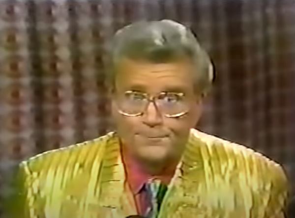 Rod is wearing a gold silk jacket w/ stripes, green silk tie & red shirt