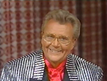 Rod is wearing a silver & black-striped jacket with black lapels & red collarless silk shirt
