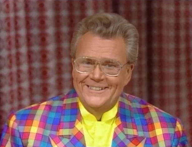 Rod is wearing a multi-colored gingham jacket & yellow collarless silk shirt