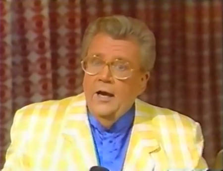 Rod is wearing a yellow gingham jacket & blue collarless silk shirt