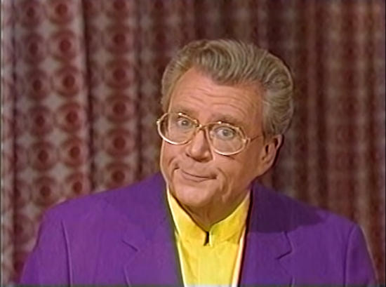 Rod is wearing a purple jacket & yellow collarless silk shirt