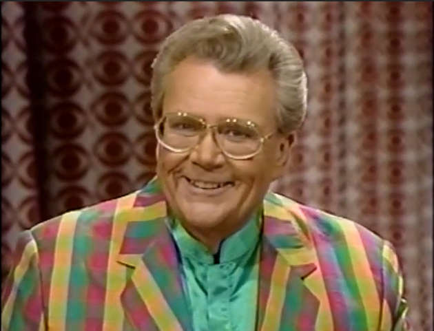 Rod is wearing a green-red-yellow gingham jacket & green collarless silk shirt