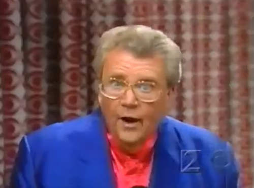 Rod is wearing a blue jacket & calmoncollarless silk shirt